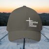 Man of God Dad Husband Embroidered Flexfit Hat displayed outdoors with a sunset backdrop.