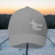 Man of God, Dad, Husband Embroidered Flexfit Hat displayed outdoors at sunset