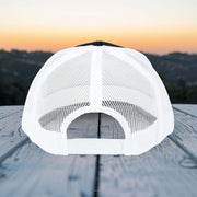 Back view of Believe In Christ Snapback Hat showcasing breathable mesh design against sunset backdrop.
