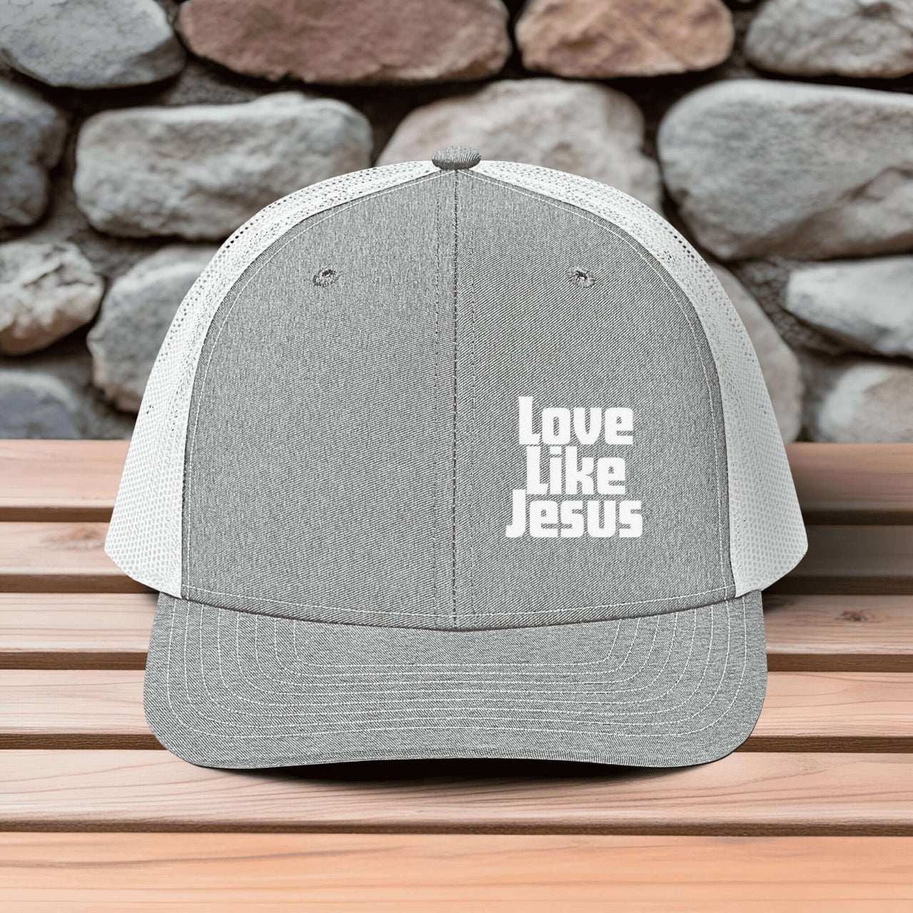 Love Like Jesus snapback hat displaying bold embroidery on a gray and white trucker style cap.