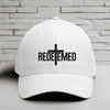 Redeemed Embroidered Flexfit Hat with a white base and black lettering showcasing the word 'REDEEMED' and a cross design.