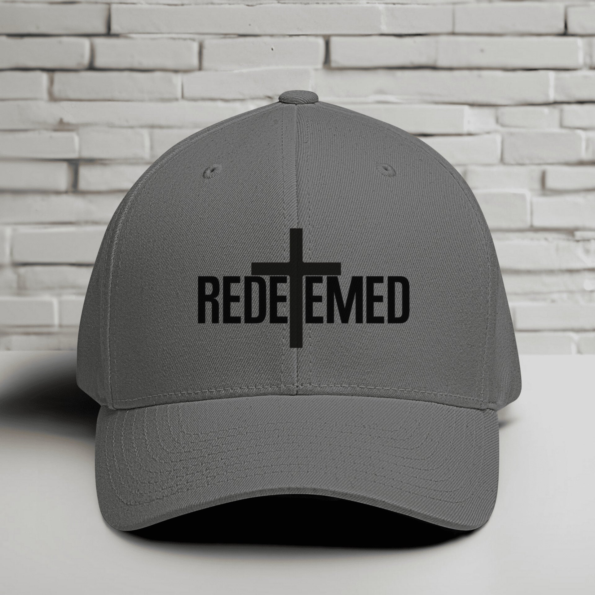 Redeemed Embroidered Flexfit Hat with a cross design, representing faith and style.