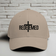 Redeemed Embroidered Flexfit Hat featuring the word Redeemed and a cross design on a khaki cap.