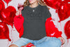 XOXO The Original Love Letters Tee Crown of Thorns Shirt on model surrounded by red heart balloons.