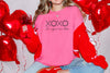 Model wearing XOXO The Original Love Letters Tee Crown of Thorns Shirt, surrounded by heart balloons.