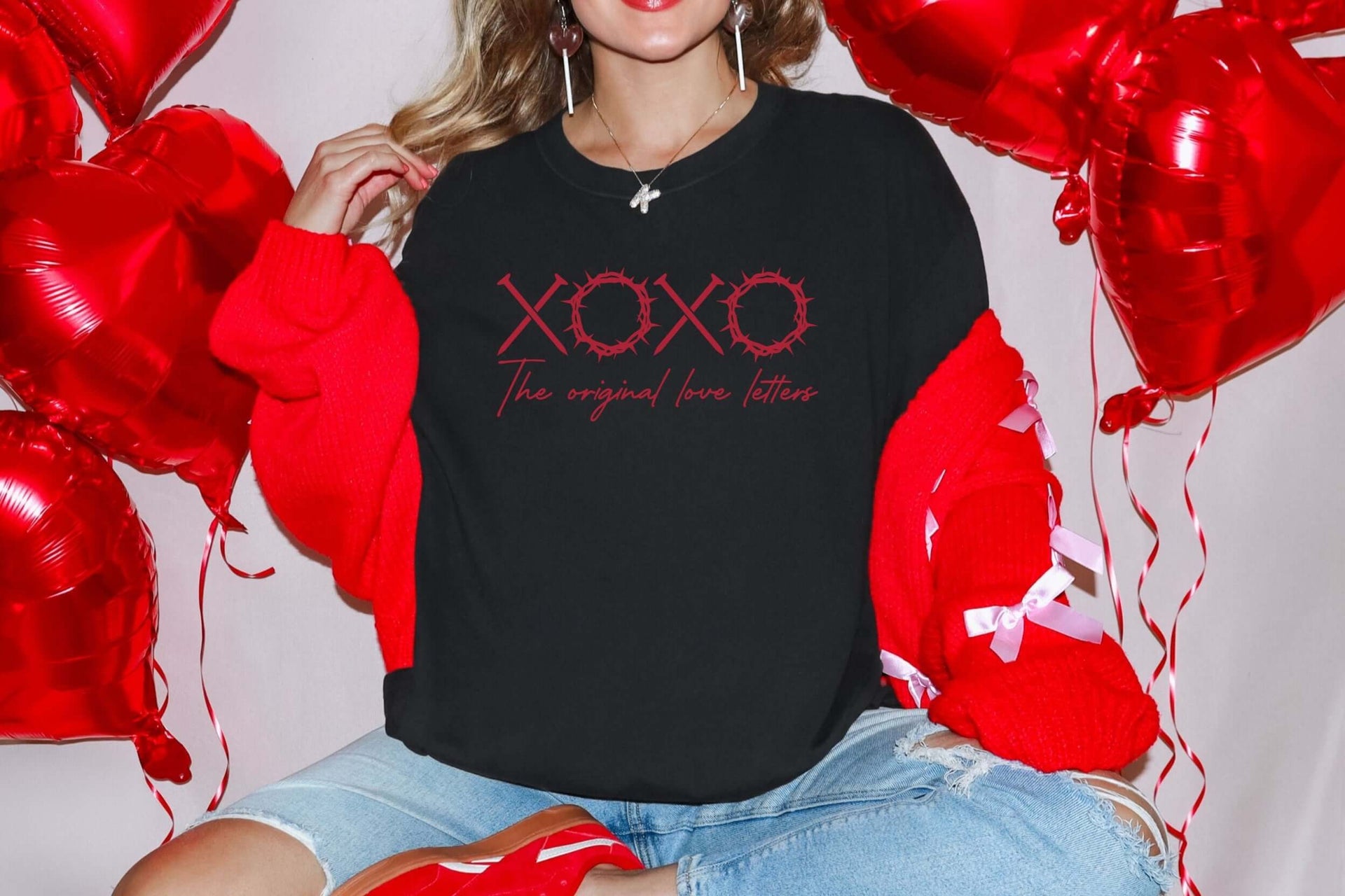 XOXO The Original Love Letters Tee Crown of Thorns Shirt worn by a model with red balloons in the background.