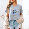 Model wearing a Jesus Loves You & Me T-shirt featuring John 15:13, in a casual setting with a cozy cardigan.