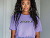 Model wearing a purple Jesus Loves Me Unisex T-shirt, showcasing faith-inspired graphic design and relaxed fit.