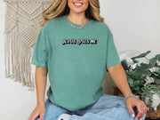 Jesus Loves Me Unisex T-shirt worn by a woman in a light green tee, featuring a bold graphic design of 'Jesus Loves Me'.