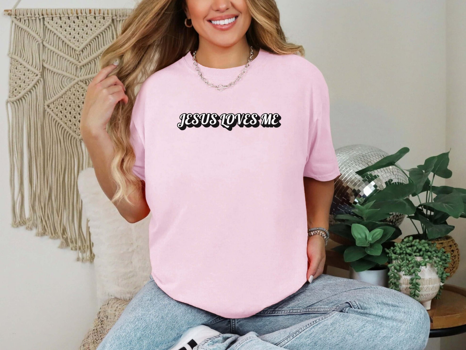 Jesus Loves Me Unisex T-shirt in pink worn by a smiling woman, perfect for church and casual outings.