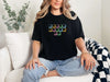 Jesus Loves Me Unisex T-Shirt featuring keyboard keys graphic on a model sitting on a sofa.