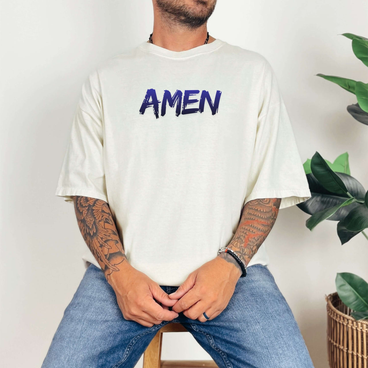 Amen Brush Stroke Text T-Shirt worn by a man with tattoos, featuring bold 'AMEN' print.