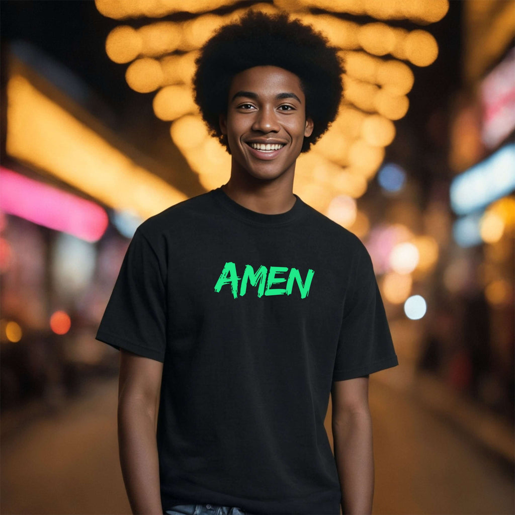 Young man wearing an Amen Brush Stroke Text T-Shirt, smiling in a vibrant street setting.