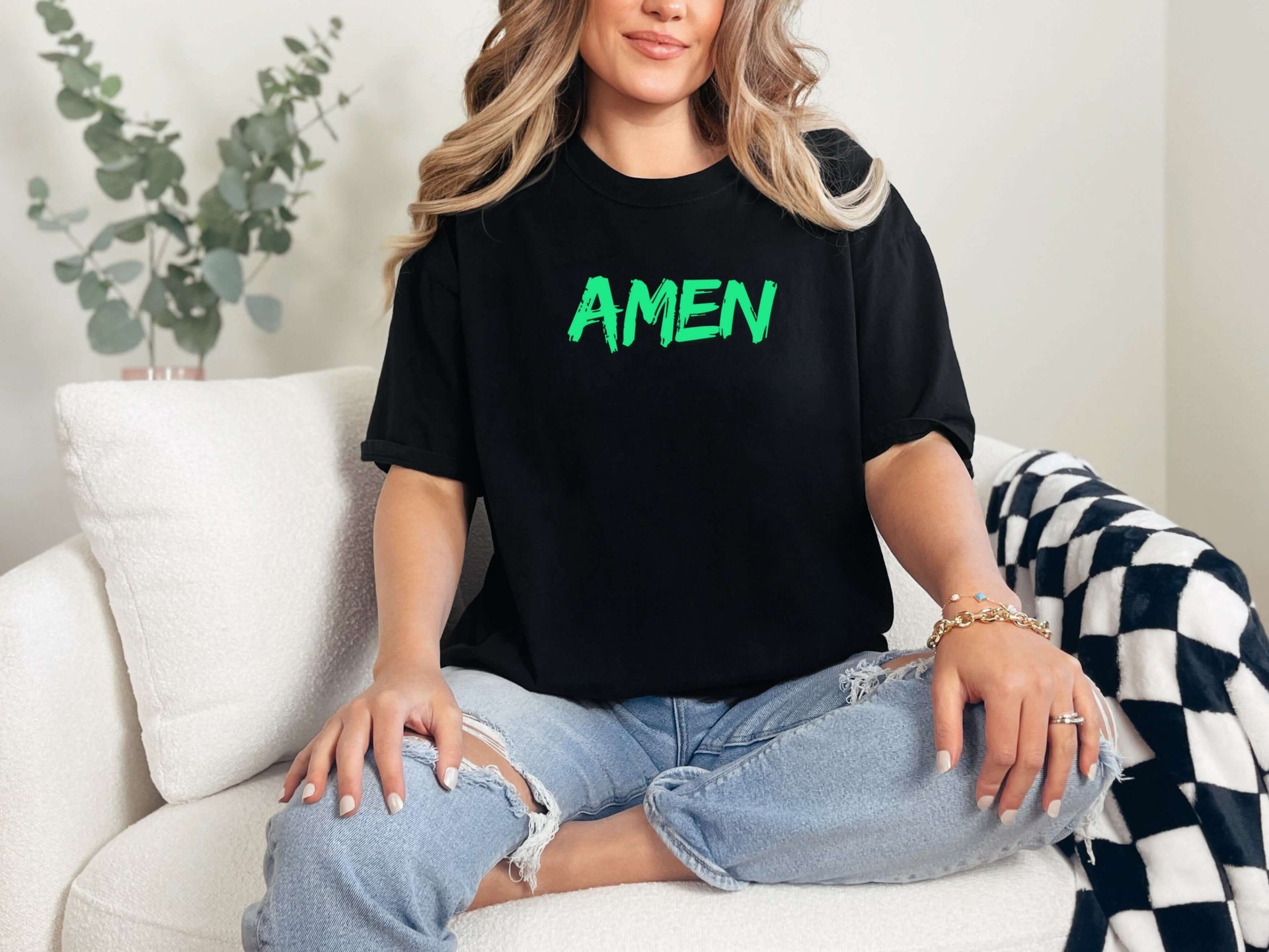 Amen Brush Stroke Unisex T-shirt worn by a woman, featuring bold 'AMEN' in green on a black tee.