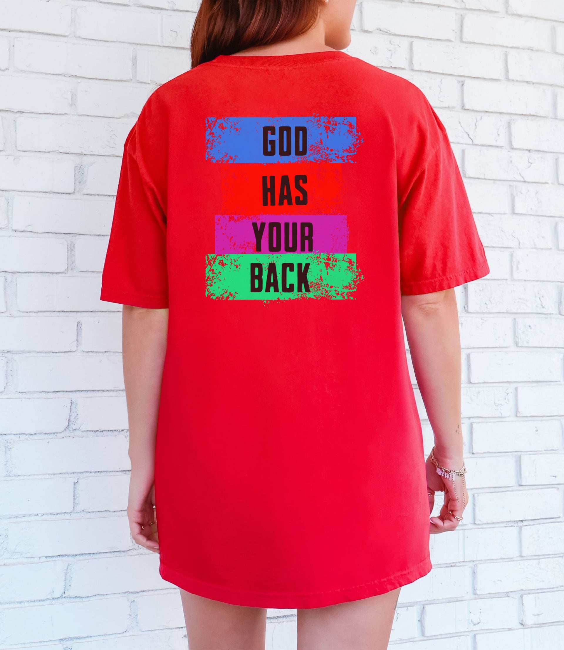 Back view of a red God Has Your Back T-Shirt featuring a colorful block design with the phrase 'God Has Your Back'.