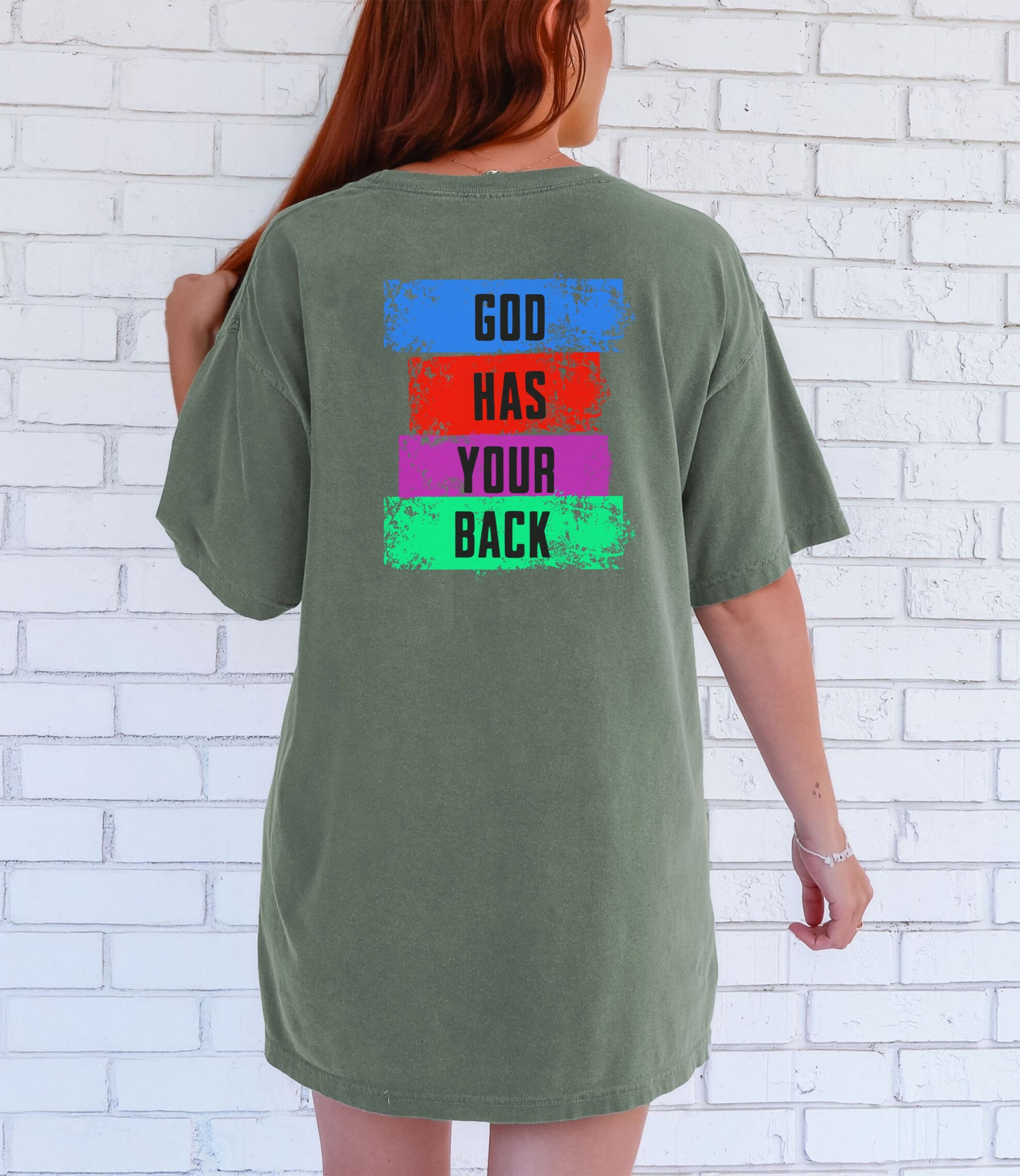 God Has Your Back T-Shirt displayed on model, featuring colorful block lettering design on the back.
