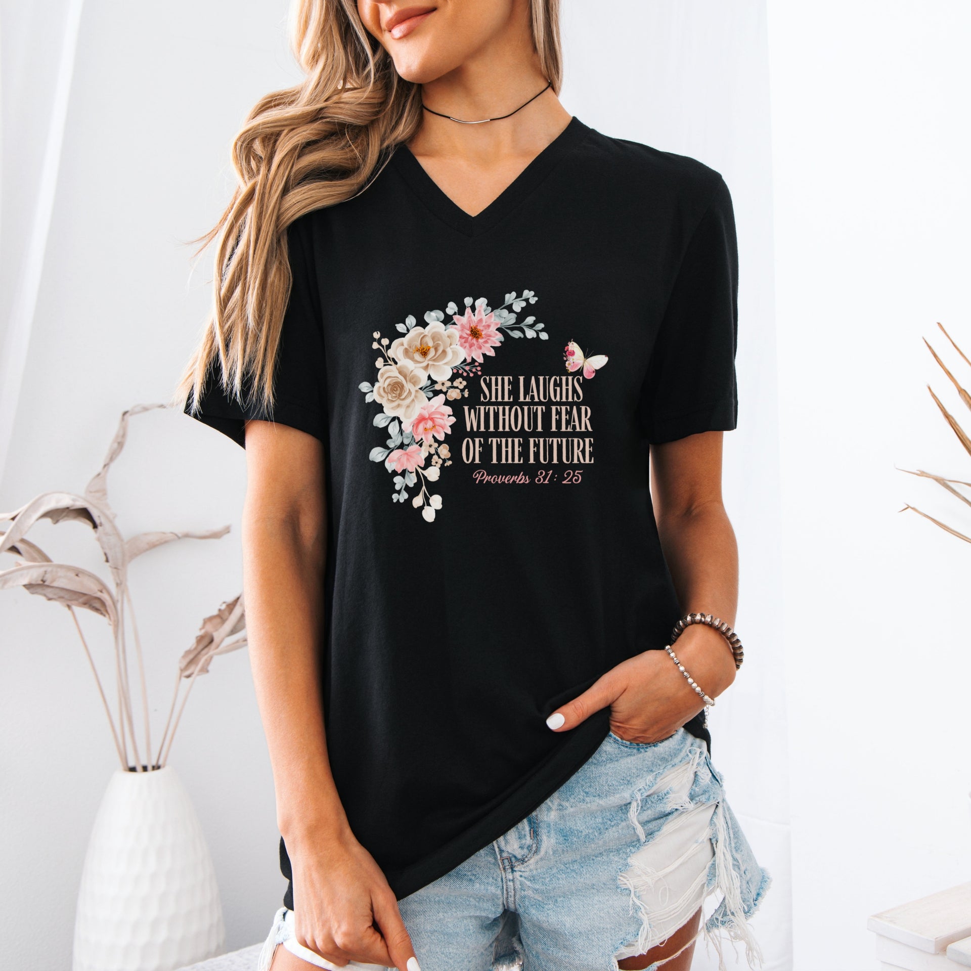 Model wearing She Laughs Without Fear Of The Future V Neck Tee with floral design in a stylish setting.