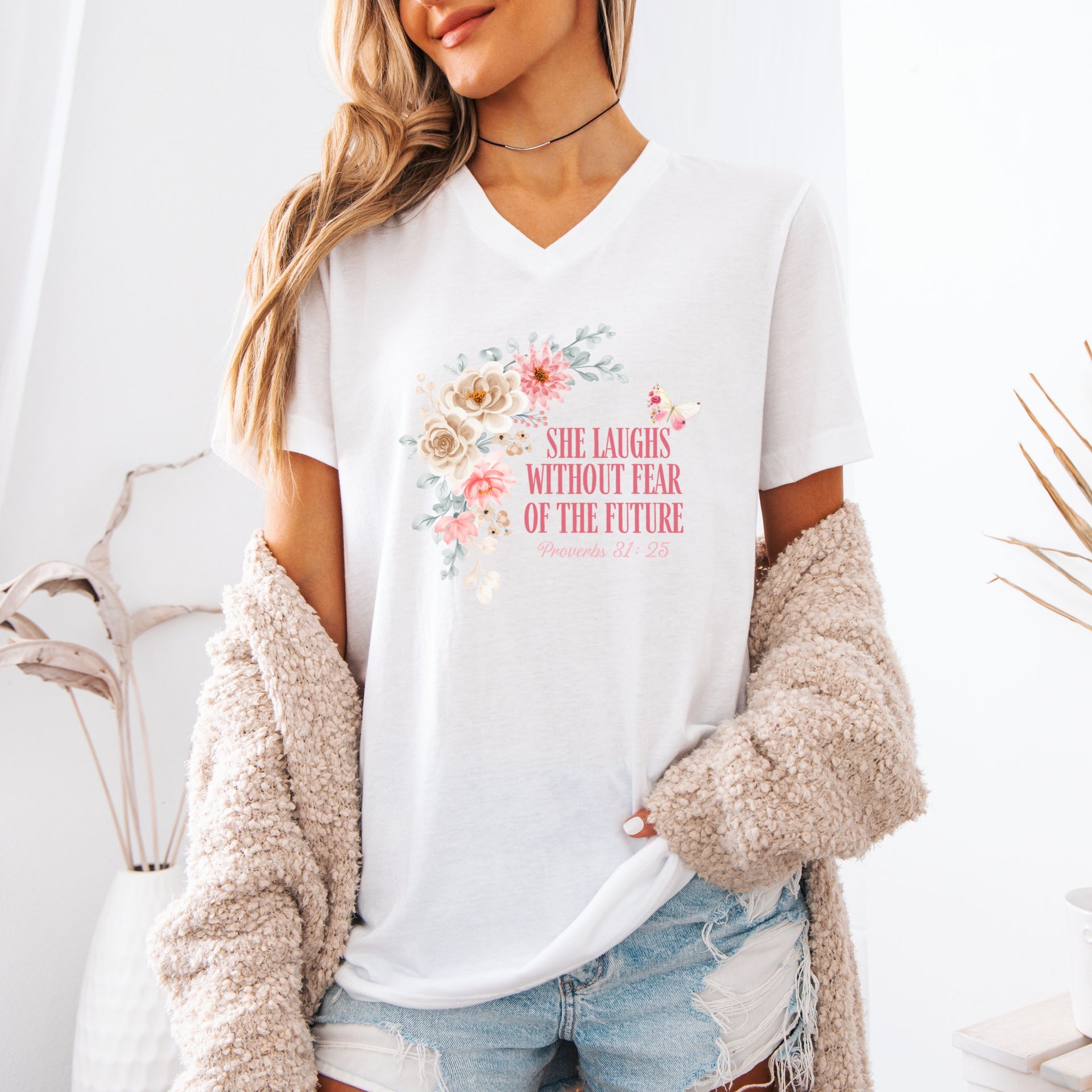 She Laughs Without Fear Of The Future V Neck Tee worn by a woman with floral design on a white tee.