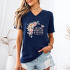 Woman wearing She Laughs Without Fear Of The Future V Neck Tee with floral design, inspired by Proverbs 31:25.
