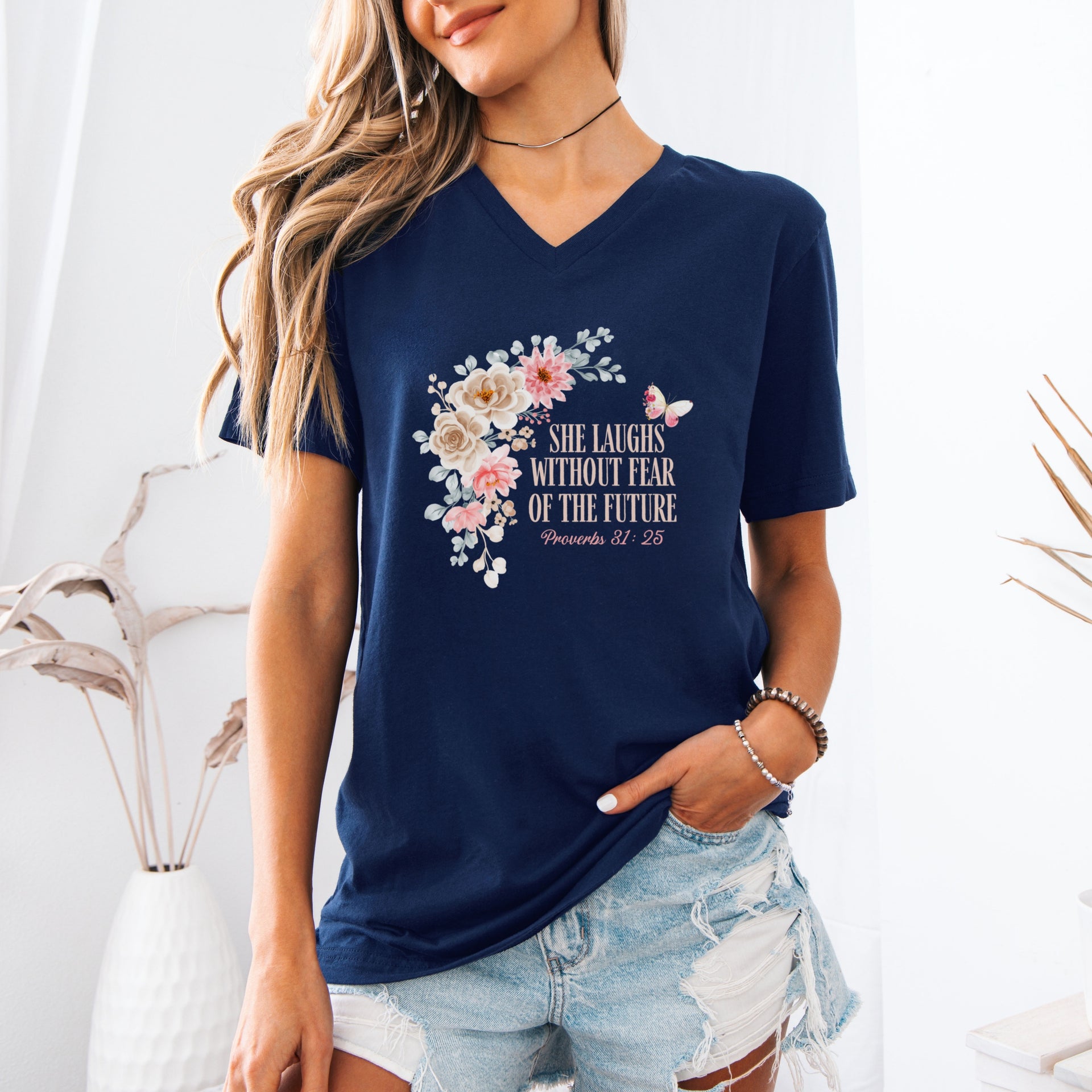 Woman wearing She Laughs Without Fear Of The Future V Neck Tee with floral design, inspired by Proverbs 31:25.