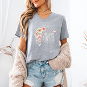 She Laughs Without Fear Of The Future V Neck Tee with floral design, worn casually by a woman in a cozy setting.
