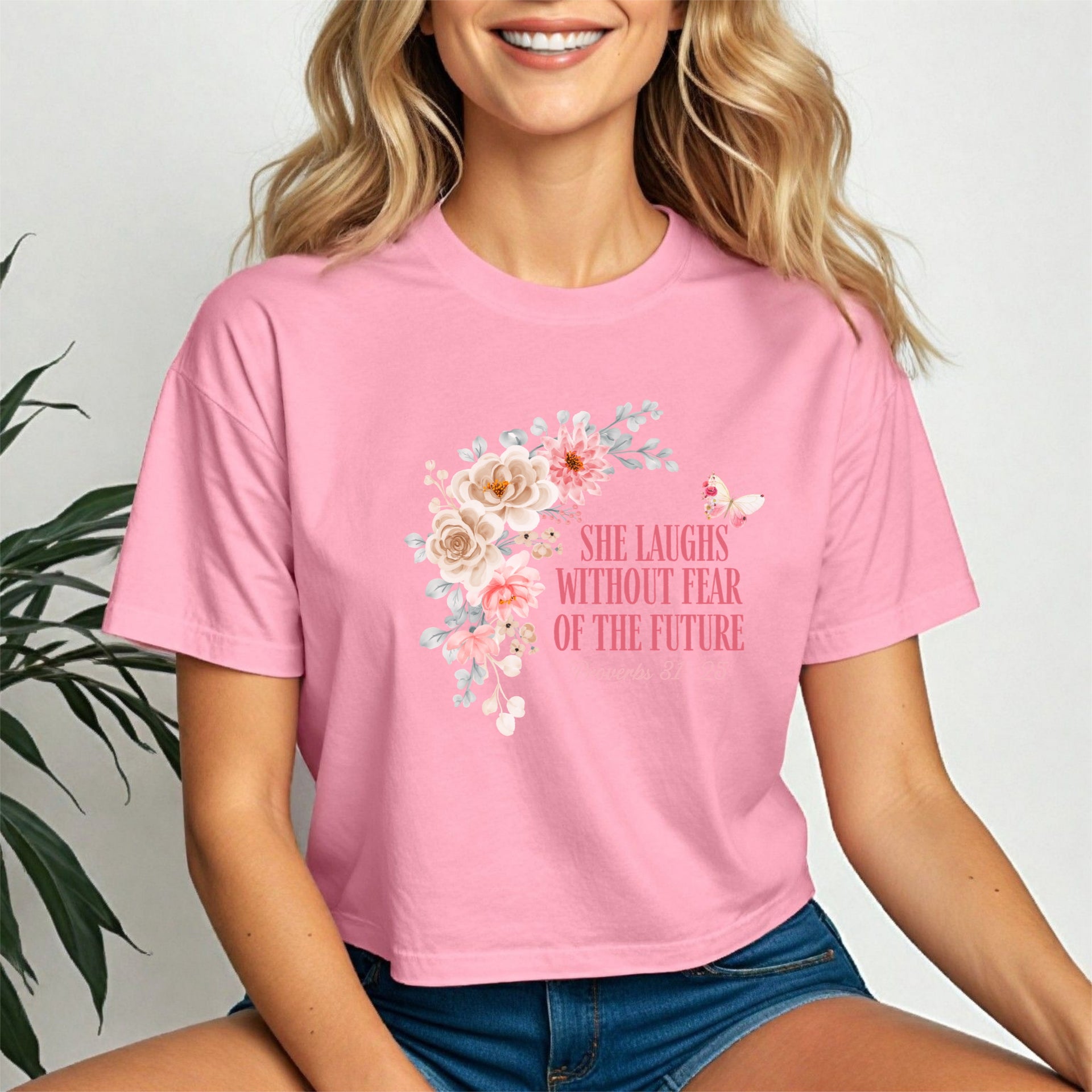 She Laughs Without Fear Of The Future Crop Tee in pink with floral design, embodying strength and confidence.