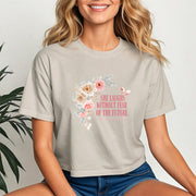 She Laughs Without Fear Of The Future Crop Tee with floral design worn by a smiling woman.