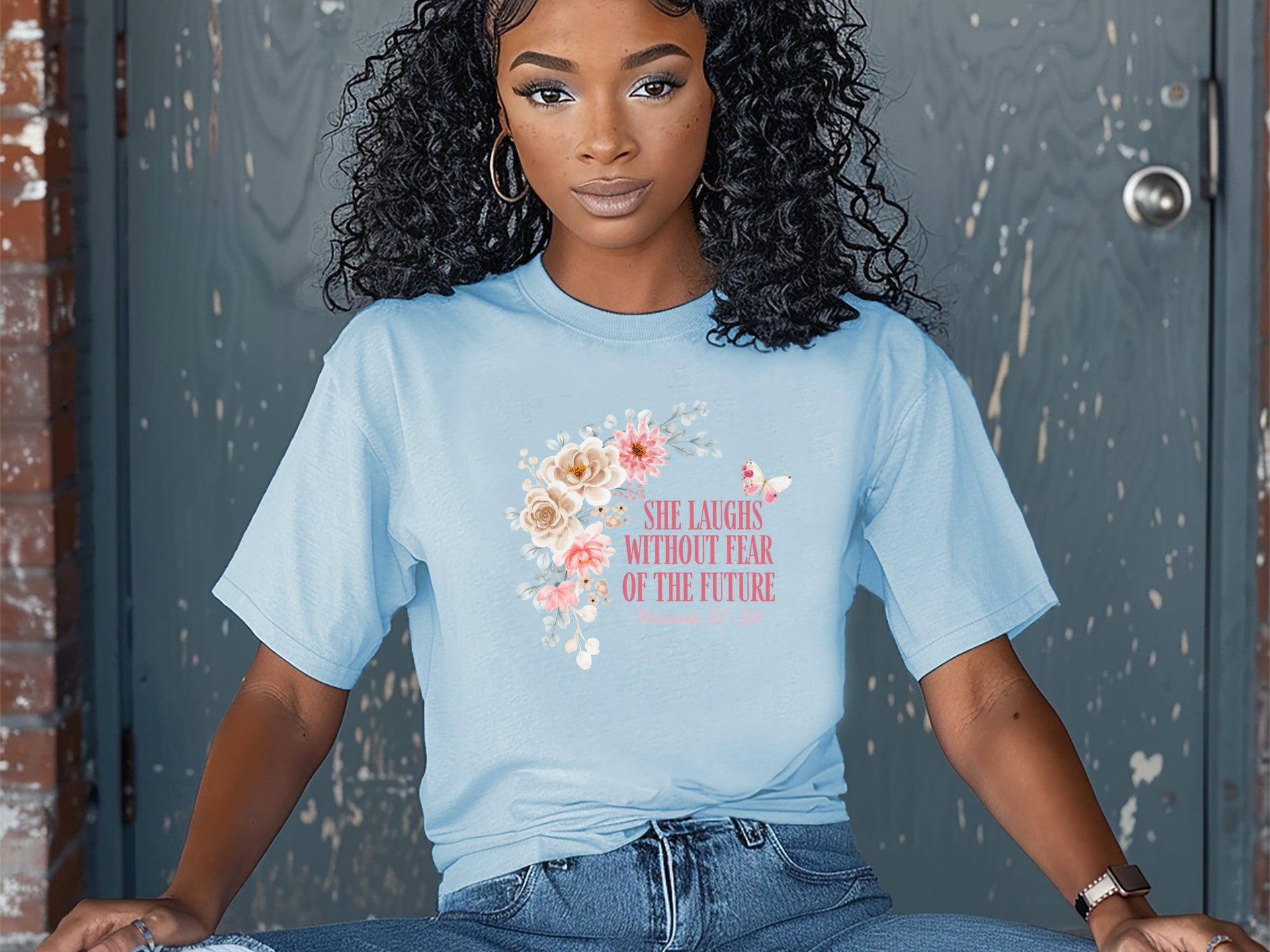 She Laughs Without Fear Of The Future Floral T Shirt in light blue with floral design worn by a woman.