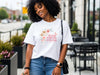 Woman wearing She Laughs Without Fear Of The Future Floral T Shirt with floral design, showcasing confidence and style.