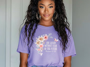 She Laughs Without Fear Of The Future Floral T Shirt displayed on a model with a floral design and purple background.