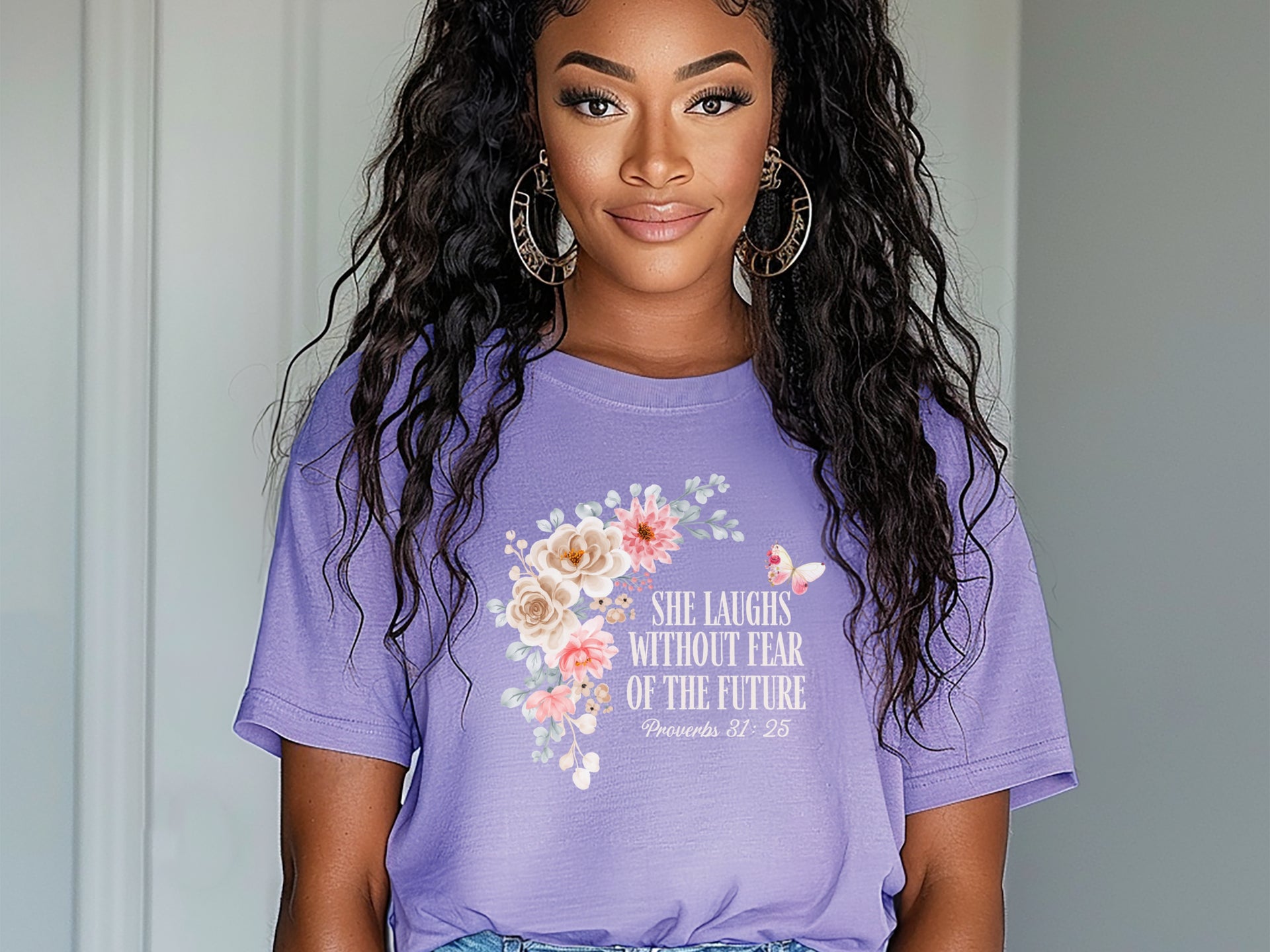 She Laughs Without Fear Of The Future Floral T Shirt displayed on a model with a floral design and purple background.