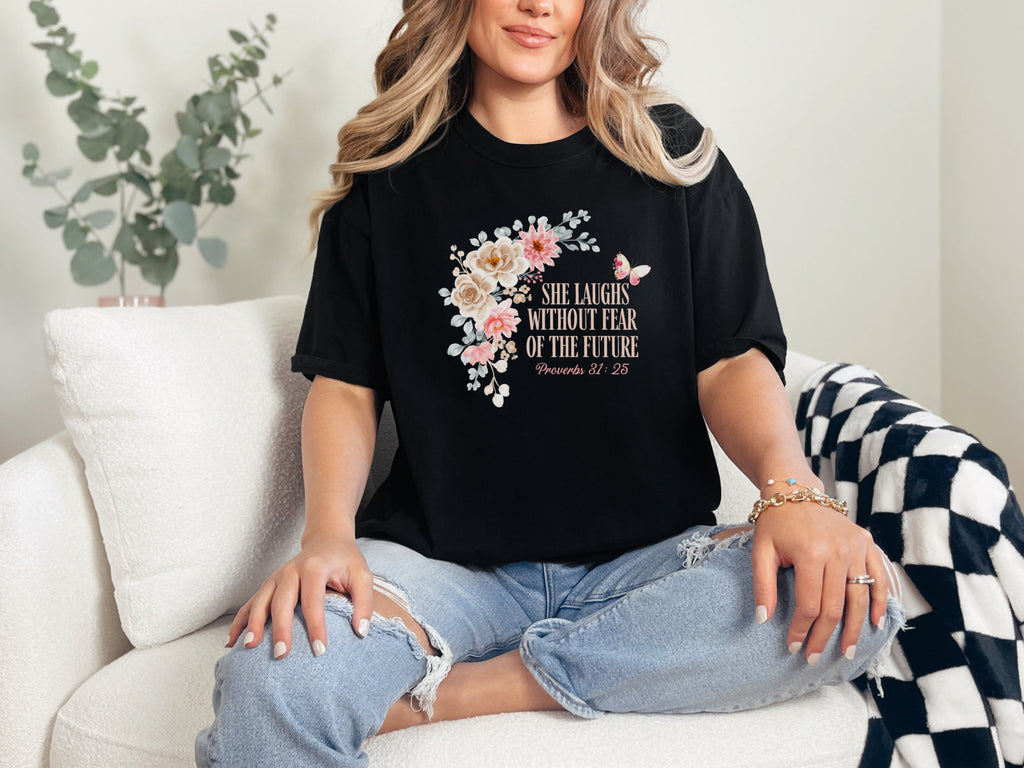 She Laughs Without Fear Of The Future Floral T Shirt displayed on a woman sitting on a couch with a floral design.