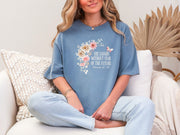 She Laughs Without Fear Of The Future Floral T Shirt worn by a woman, featuring floral design and Proverbs 31:25 text.