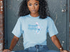 Model wearing a light blue Strength And Dignity Proverbs 31 25 Butterfly T Shirt with butterfly graphic.