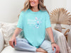 Strength And Dignity Proverbs 31 25 Butterfly T Shirt worn by a woman sitting on a couch, featuring a butterfly graphic.