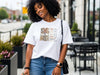 She Is Mom Floral Typography T Shirt worn by a smiling woman in casual setting with floral design.