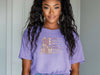 Model wearing She Is Mom Floral Typography T Shirt with floral design, showcasing the beauty of motherhood.