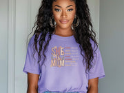 Model wearing She Is Mom Floral Typography T Shirt with floral design, showcasing the beauty of motherhood.