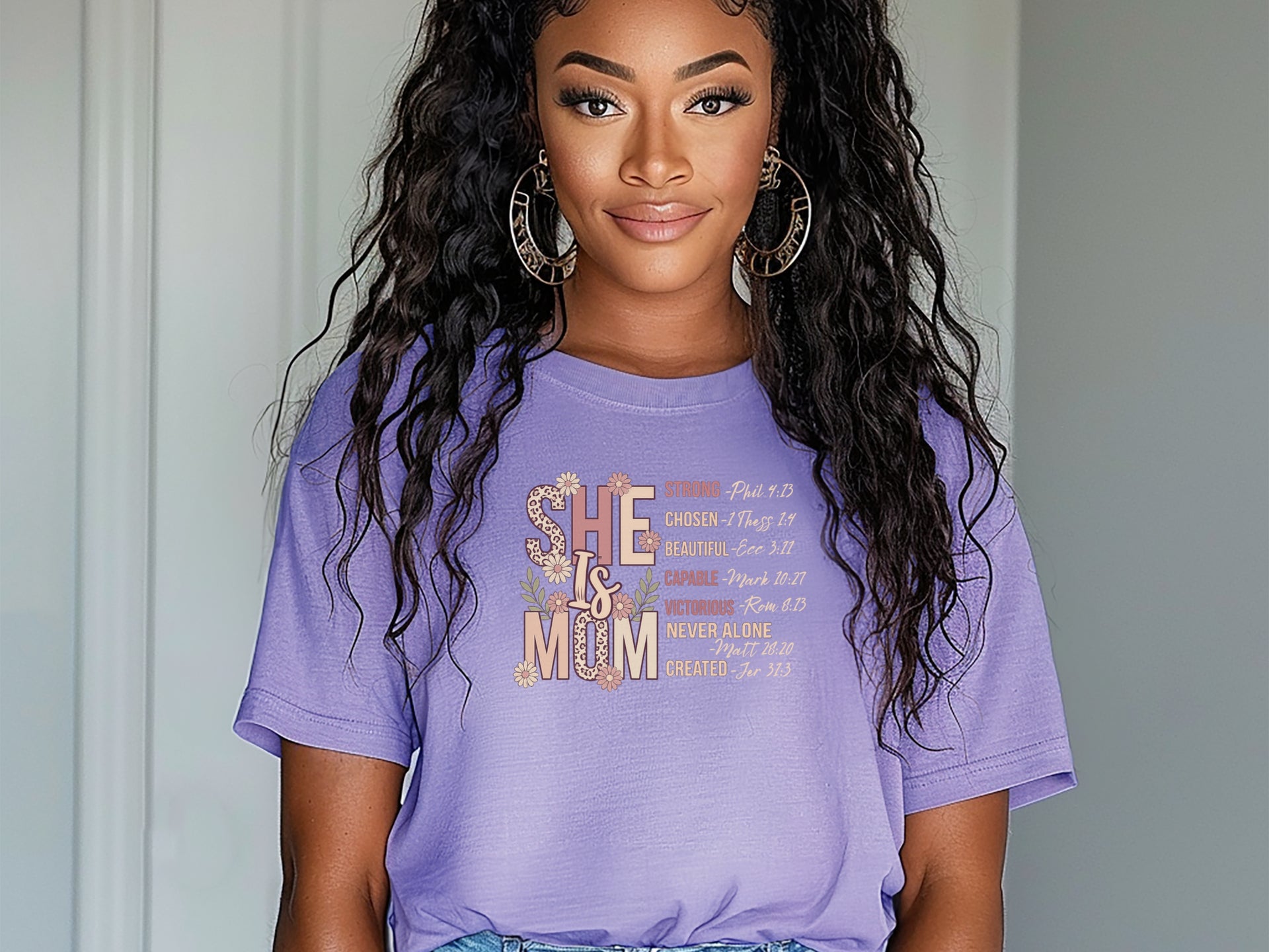 Model wearing She Is Mom Floral Typography T Shirt with floral design, showcasing the beauty of motherhood.