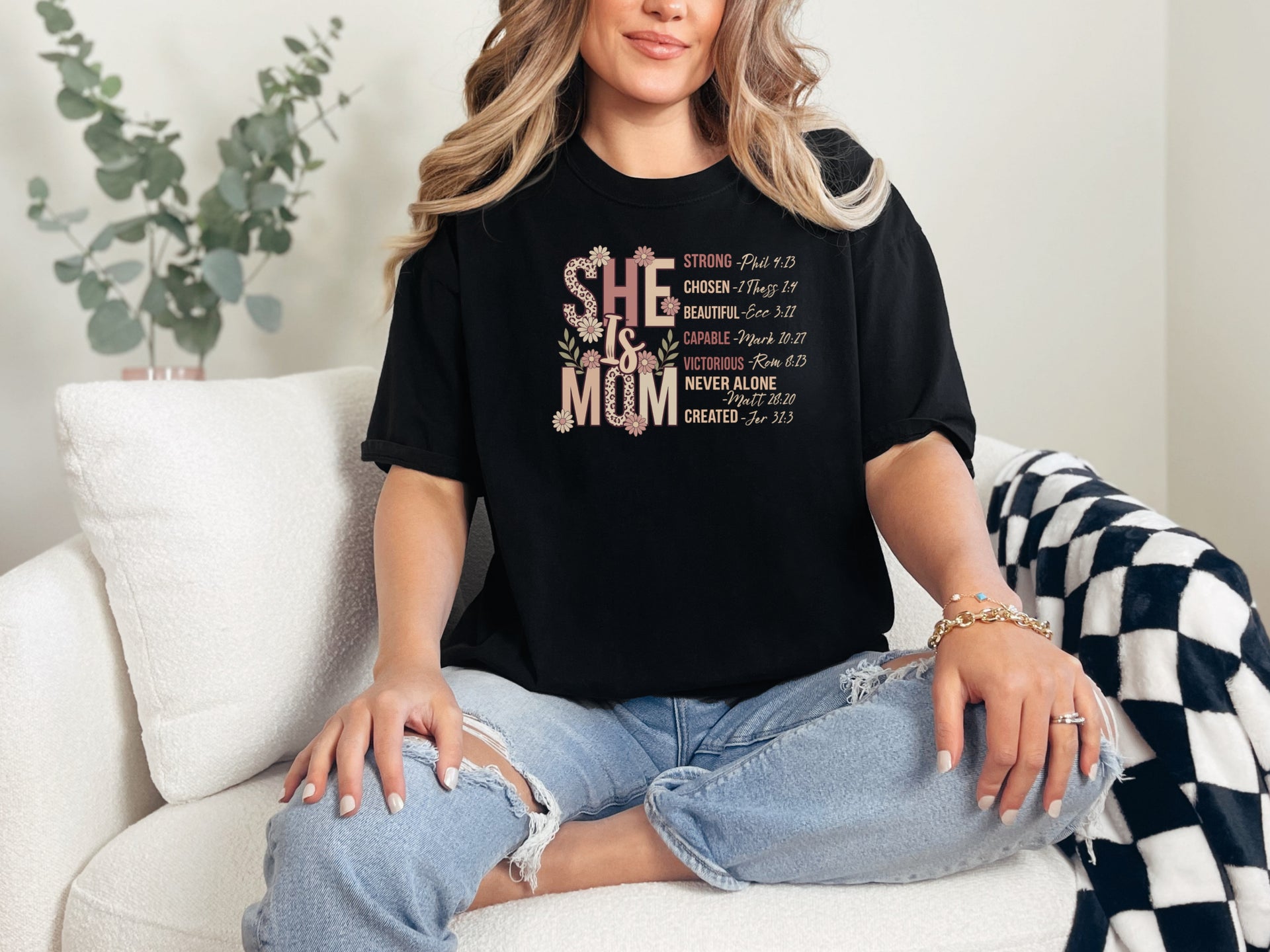 She Is Mom Floral Typography T Shirt worn by a woman, showcasing a floral design and powerful motherhood messages.