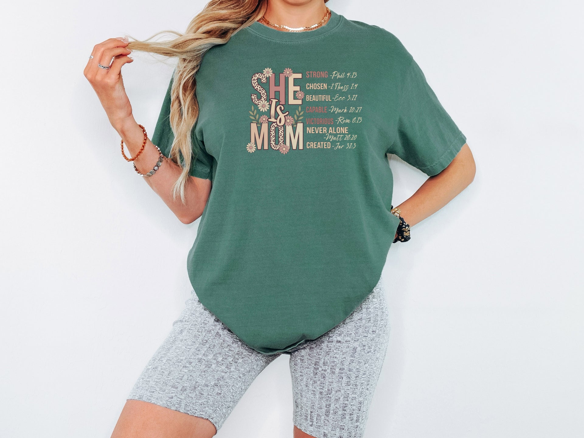 She Is Mom Floral Typography T Shirt on model, showcasing soft floral design celebrating motherhood.