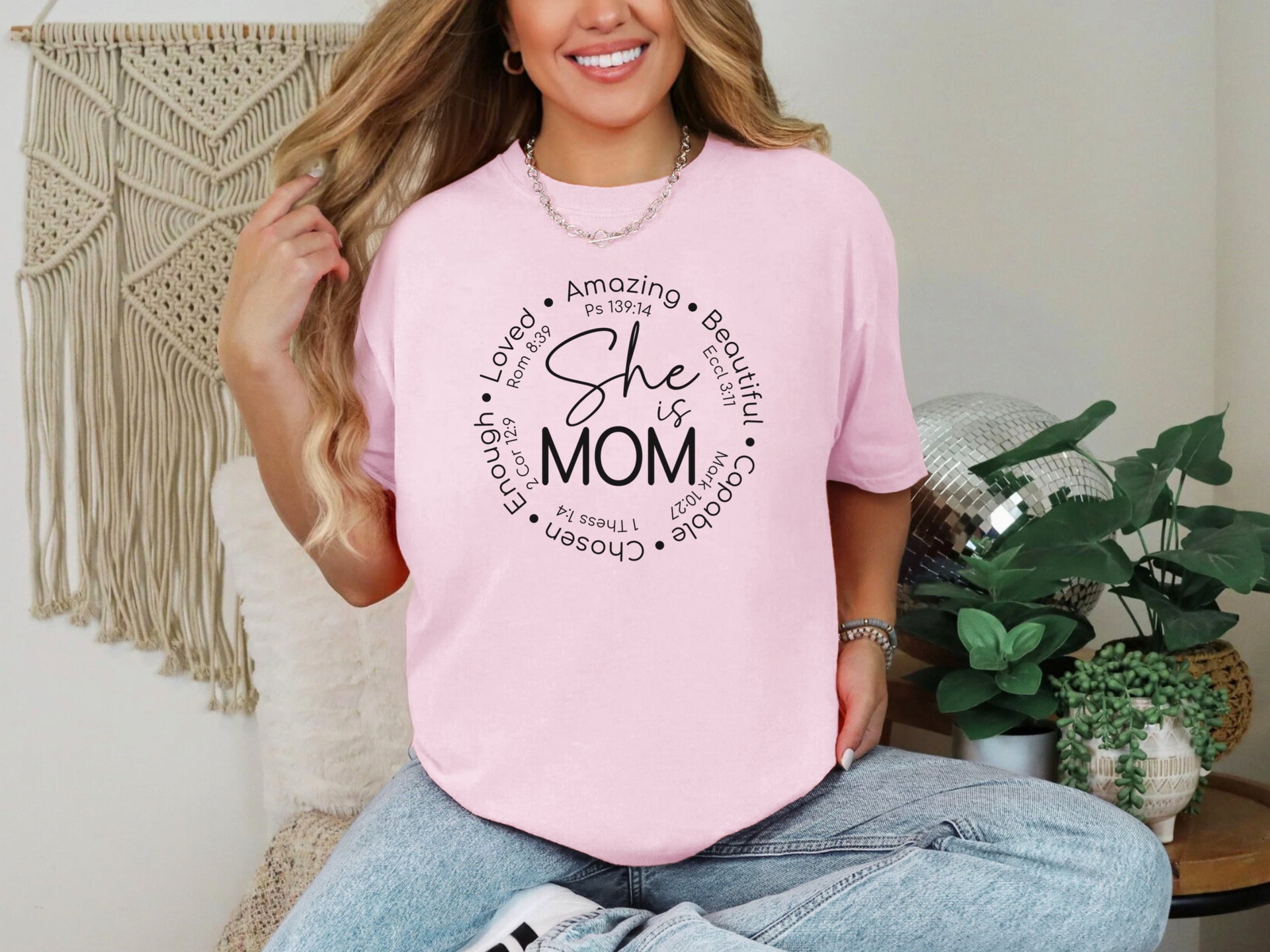 She Is Mom Circle Script T Shirt worn by a smiling woman, featuring a soft pink color and circular script design highlighting motherhood.