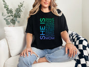 A woman wearing a SHE IS vertical affirmation mom T-Shirt with positive affirmations, showcasing strength in motherhood.