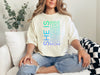 Model wearing SHE IS vertical affirmation mom T-Shirt with uplifting words. Comfortably styled for everyday wear.