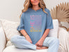 SHE IS vertical affirmation mom T-Shirt worn by a woman, showcasing vibrant positive affirmations for moms.
