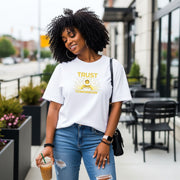 Woman wearing a Trust God With Tomorrow T-Shirt, enjoying a drink while walking in a city setting.
