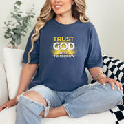 Woman wearing a blue Trust God With Tomorrow T-Shirt, promoting faith and confidence with a stylish design.