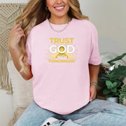 Trust God With Tomorrow T-Shirt displayed on a smiling woman wearing a pink t-shirt, embodying faith and confidence.