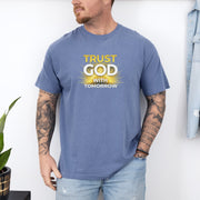 Trust God With Tomorrow T-Shirt modeled by a man with tattoos, featuring a bright design on a blue t-shirt.