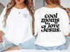 Model wearing a Cool Moms Love Jesus T Shirt featuring heart line art and bold lettering on the back.